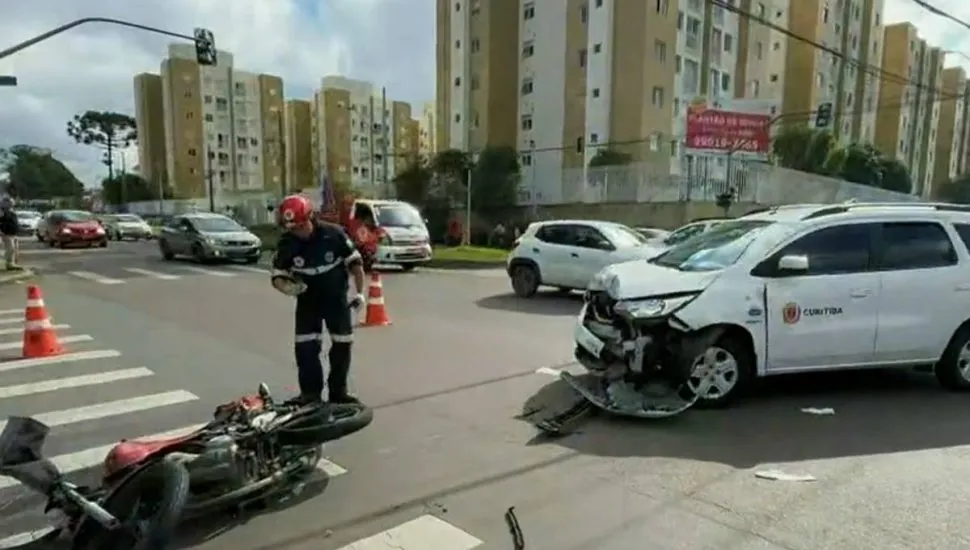 Imagem mostra um carro acidentado e uma moto caída no chão.