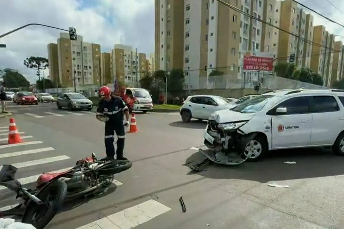 Imagem mostra um carro acidentado e uma moto caída no chão.