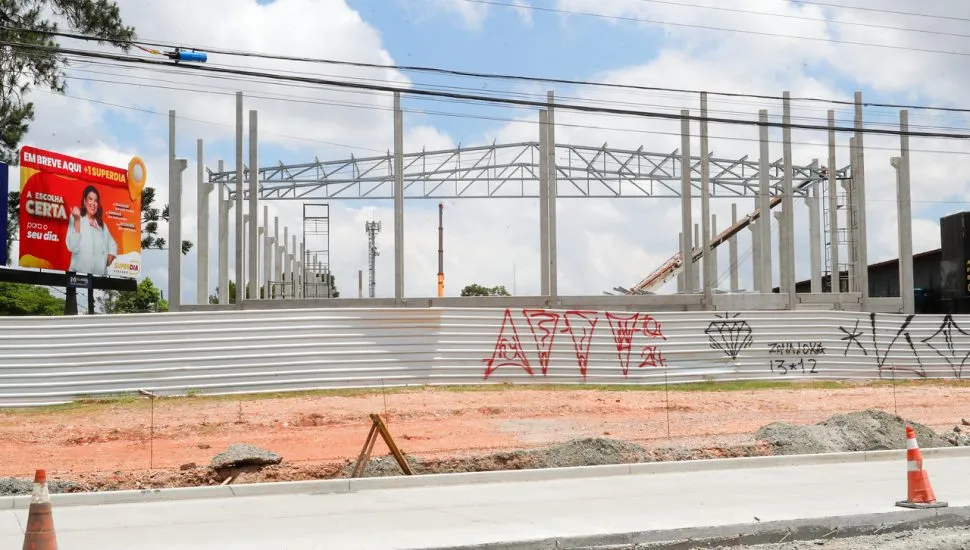 imagem mostra, a partir da visão de quem está na rua, a estrutura que está sendo erguida em colunas pré moldadas para a construção do supermercado