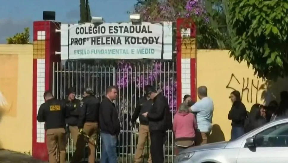 Na imagem, pessoas reunidas em frente à entrada do Colégio Estadual Professora Helena Kolody, em Cambé, no Paraná.