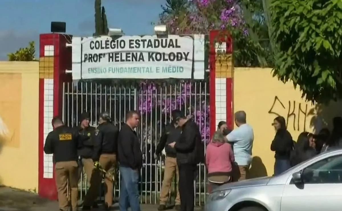 Na imagem, pessoas reunidas em frente à entrada do Colégio Estadual Professora Helena Kolody, em Cambé, no Paraná.