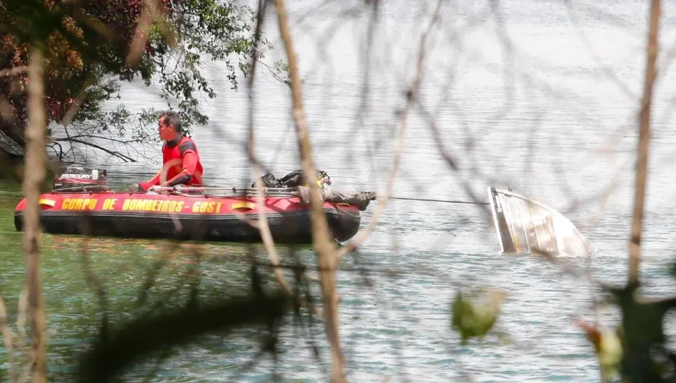 Na imagem, buscas dos bombeiros na Represa do Passaúna e barco que naufragou