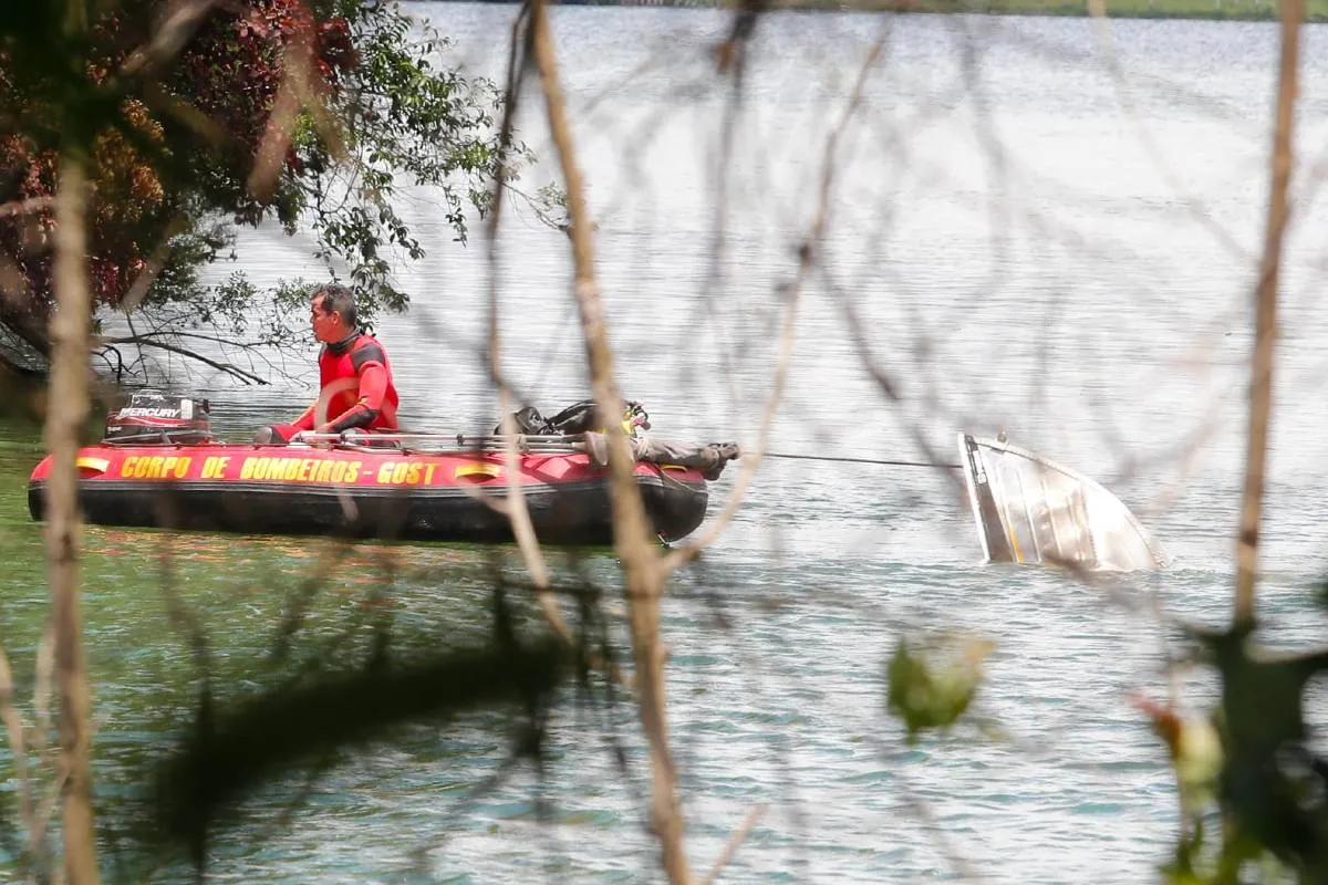 Na imagem, buscas dos bombeiros na Represa do Passaúna e barco que naufragou