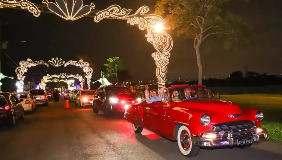 Imagem mostra um carro antigo desfilando no Natal de Curitiba.