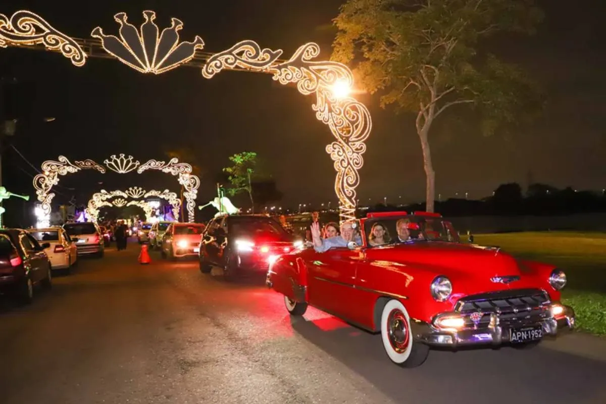 Imagem mostra um carro antigo desfilando no Natal de Curitiba.