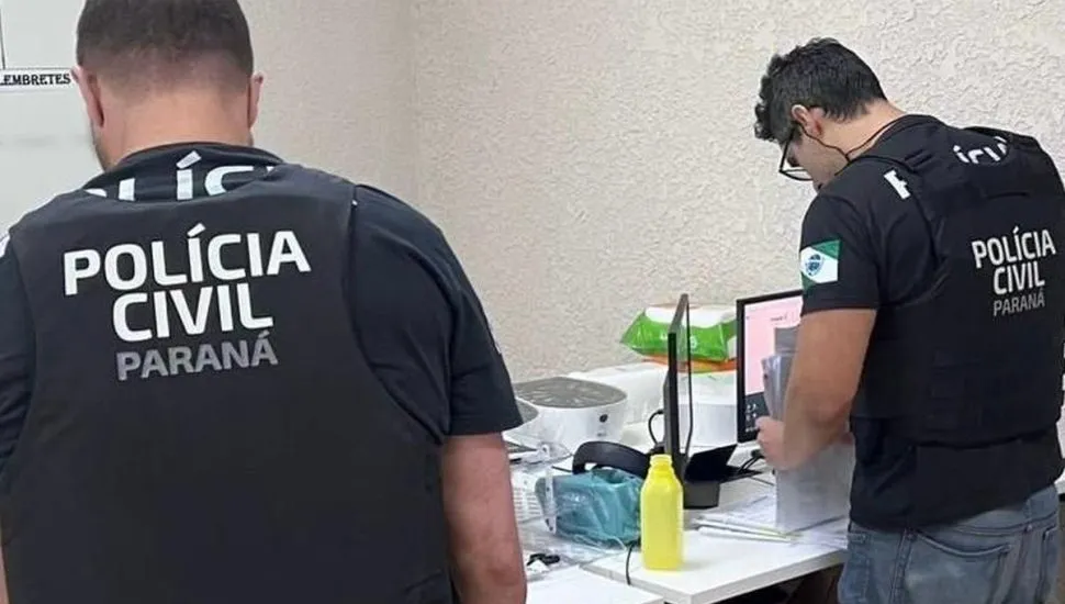 Na imagem, policiais de costas analisam documentos