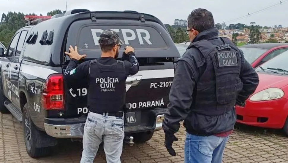 Imagem mostra um carro da polícia e policiais da PCPR.