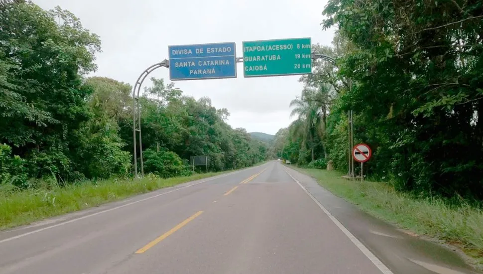 Na imagem, rodovia PR-412, com placa da divisa entre os estados do Paraná e Santa Catarina