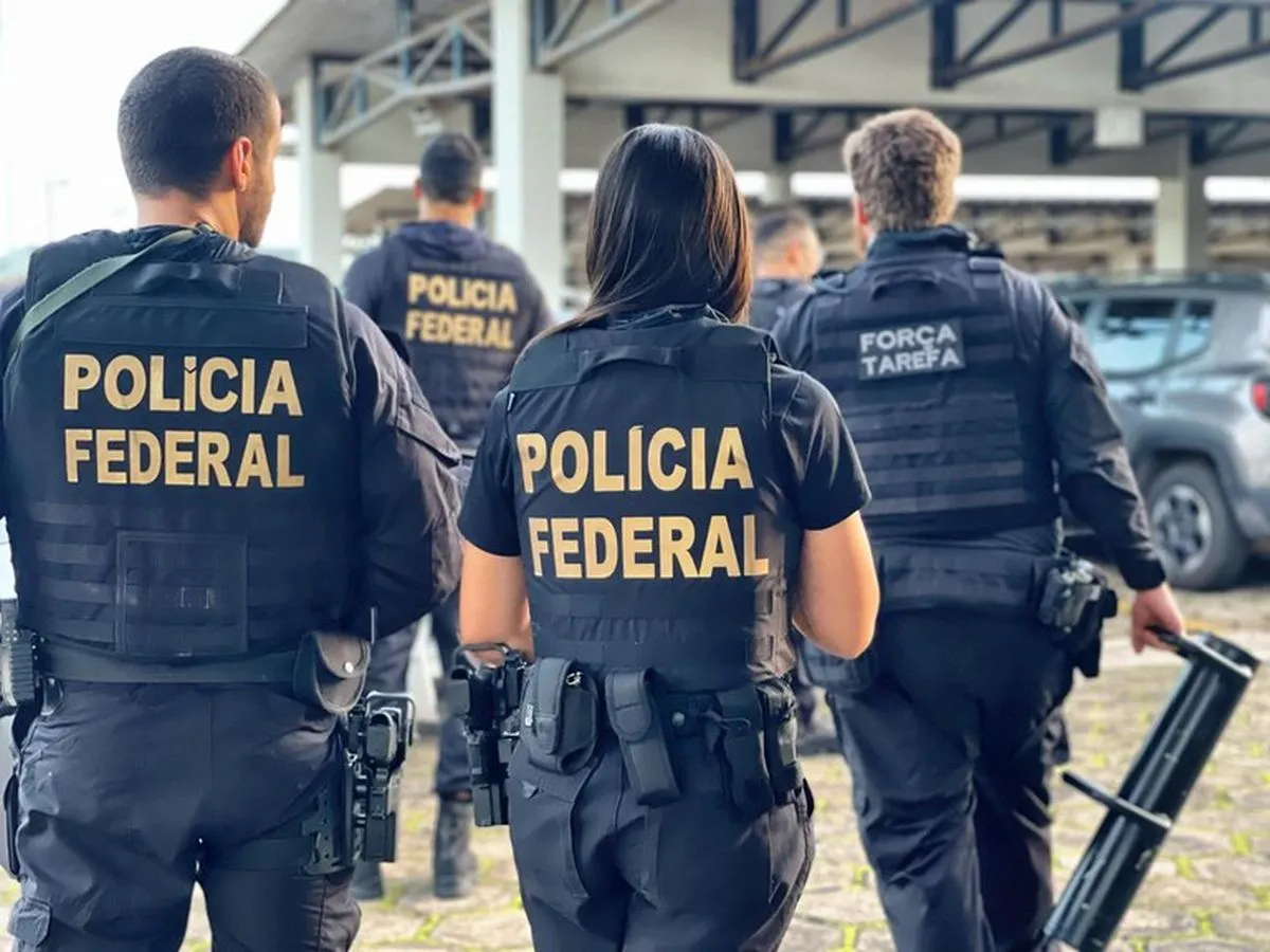 Na imagem, grupo de policiais da Polícia Federal, de costas