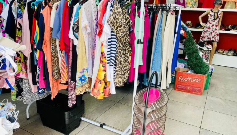 Na imagem, roupas do bazar nas araras