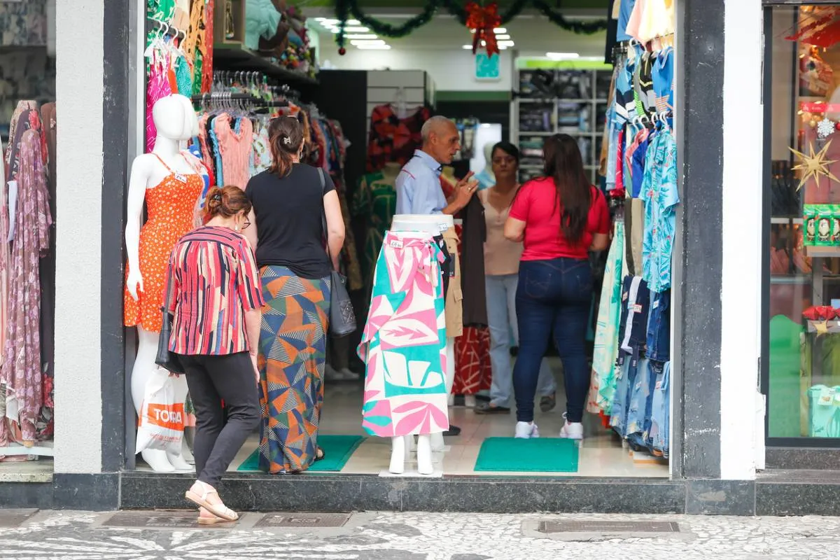 Imagem mostra pessoas dentro de uma loja de roupas