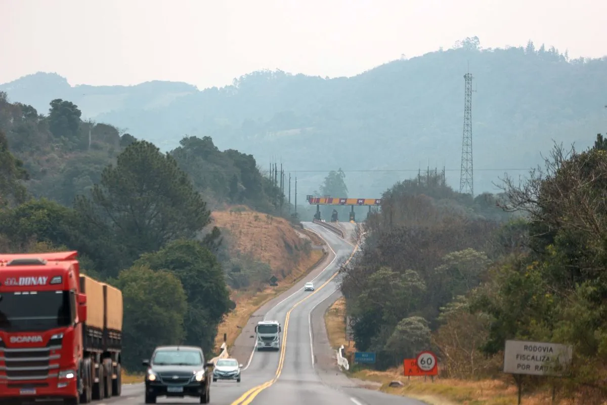 Na imagem, rodovia do Paraná com praça de pedágio ao fundo