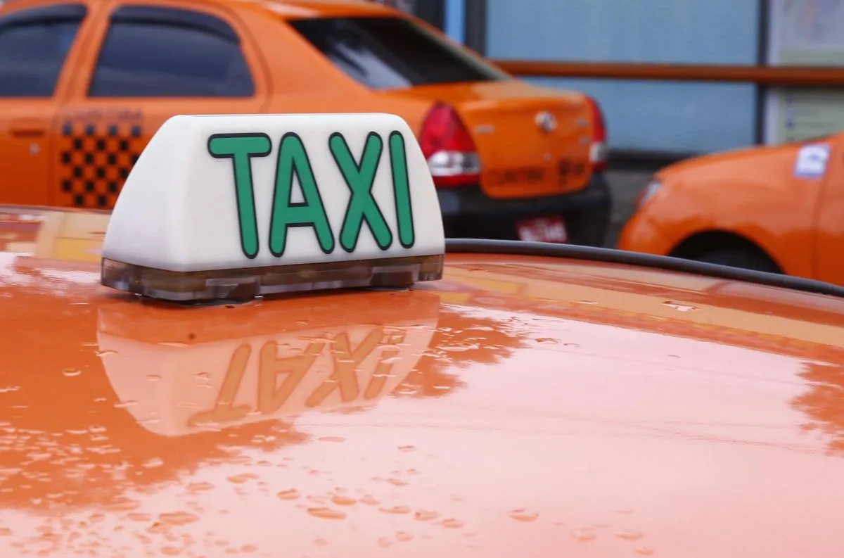 Na imagem, táxis de cor da laranja, em Curitiba