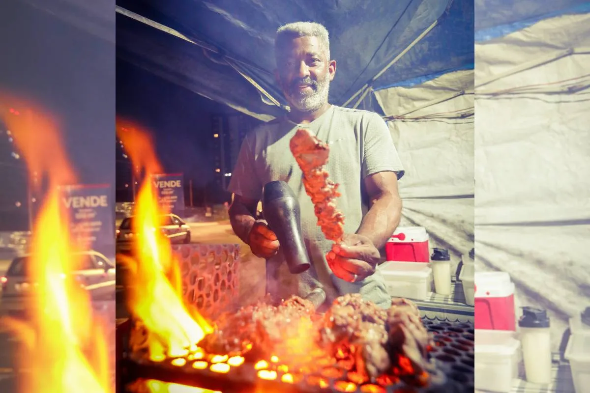 Imagem mostra uma barraca de espetinho com vários espetinhos de diferentes "sabores" na grelha.