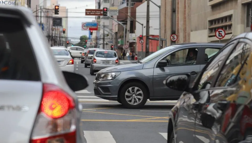 Imagem mostra carros em uma rua de Curitiba.