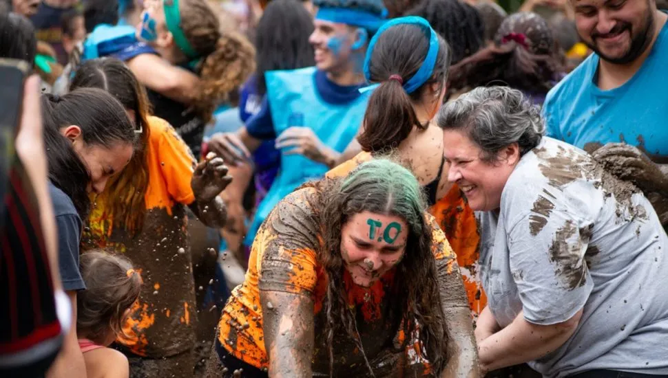 Imagem mostra mulheres felizes, cobertas de lama