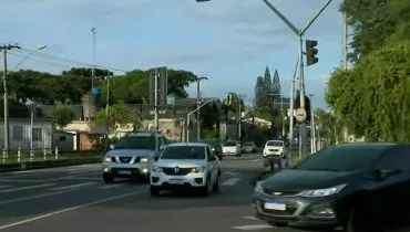 Imagem mostra carros andando em um cruzamento sem sinaleiro.