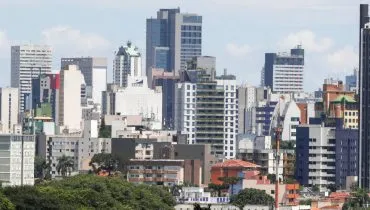 Imagem mostra prédios em Curitiba com árvores na base