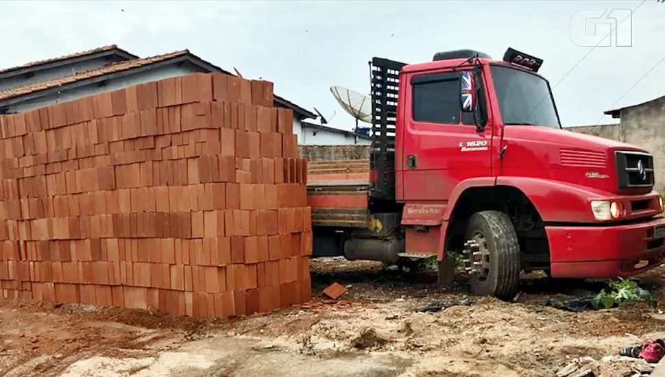 Motorista e ajudante descarregam carga de tijolo e deixam caminhão preso no terreno