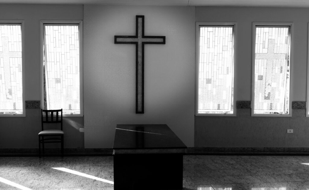 capela mortuária em preto e branco com uma cruz ao fundo