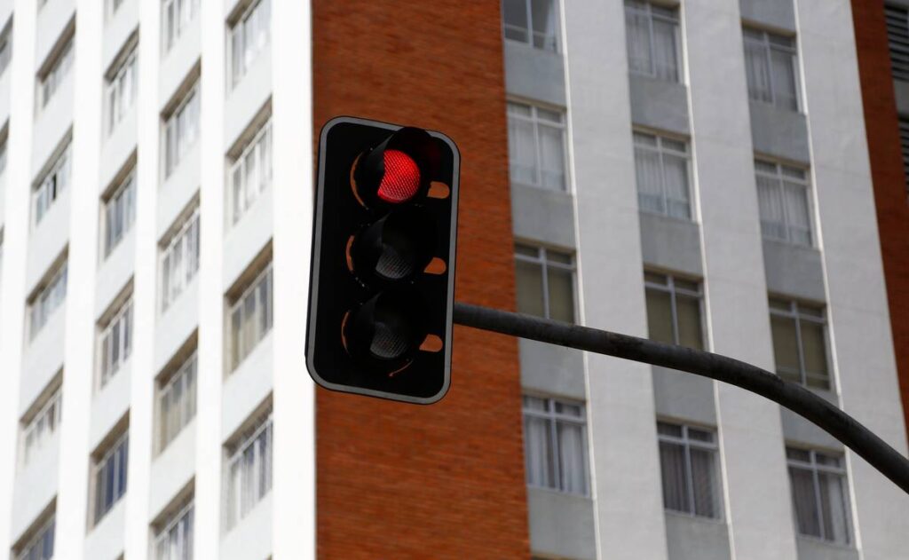 Imagem mostra um sinaleiro vermelho em Curitiba