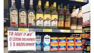 Imagem mostra uma prateleira de supermercado com a seguinte frase: Aqui tem o "mé", o leite das crianças e o absorvente da mulher.