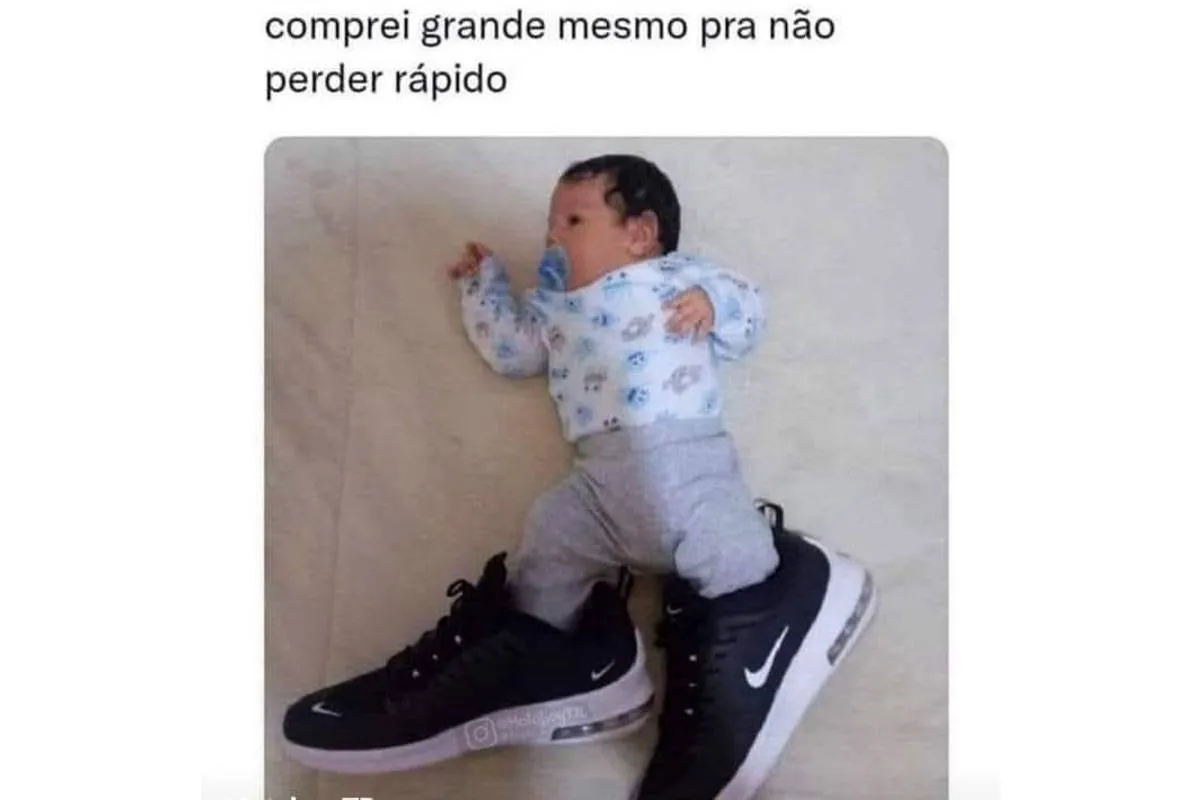 Imagem mostra um bebe usando um tenis gigante que o pai comprou para economizar.