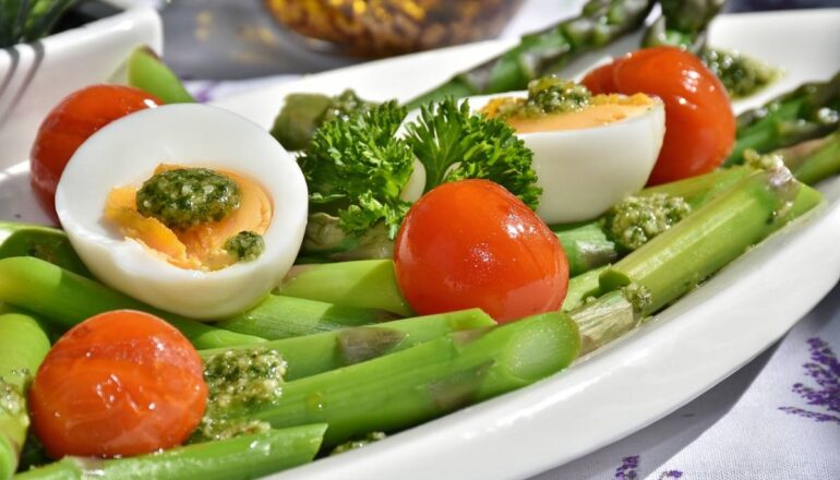 Uma refeição saudável com aspargos, tomates, ovos e temperos